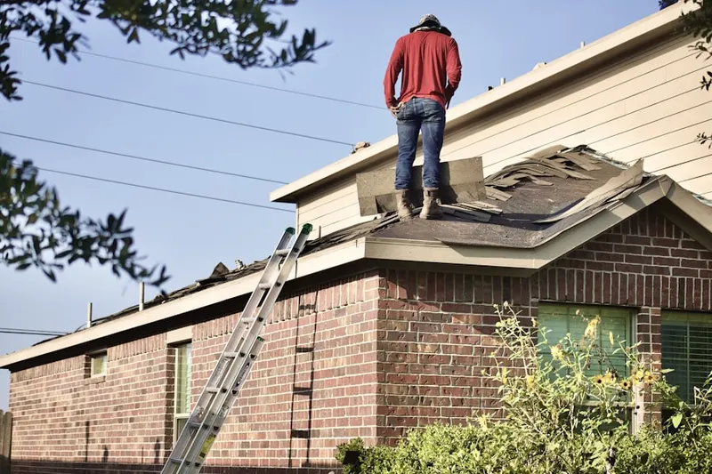 Professional roofer working on a residential roof in Feaster Park